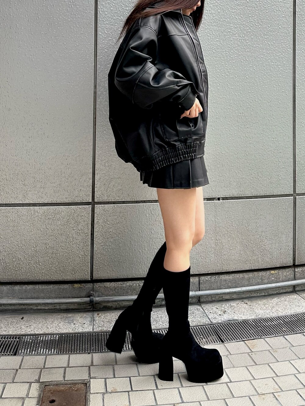 ブラック系のブルゾン、ブラック系のニット/セーター、ブラック系のスカートを着用したレディースの秋コーディネートの5枚目の写真