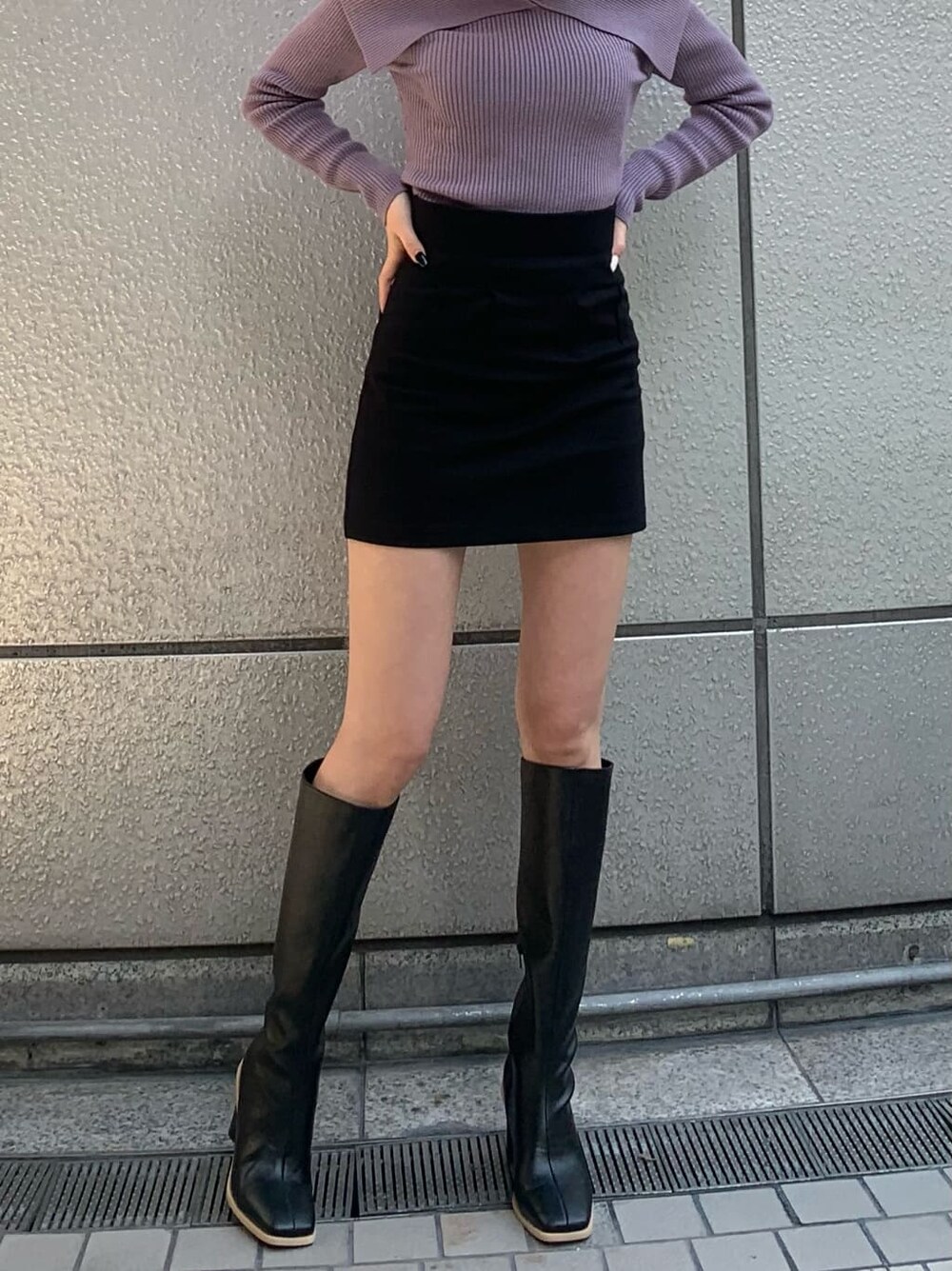 ブラック系のブーツ、パープル系のニット/セーター、ブラック系のトレンチコートを着用したレディースの冬コーディネートの3枚目の写真