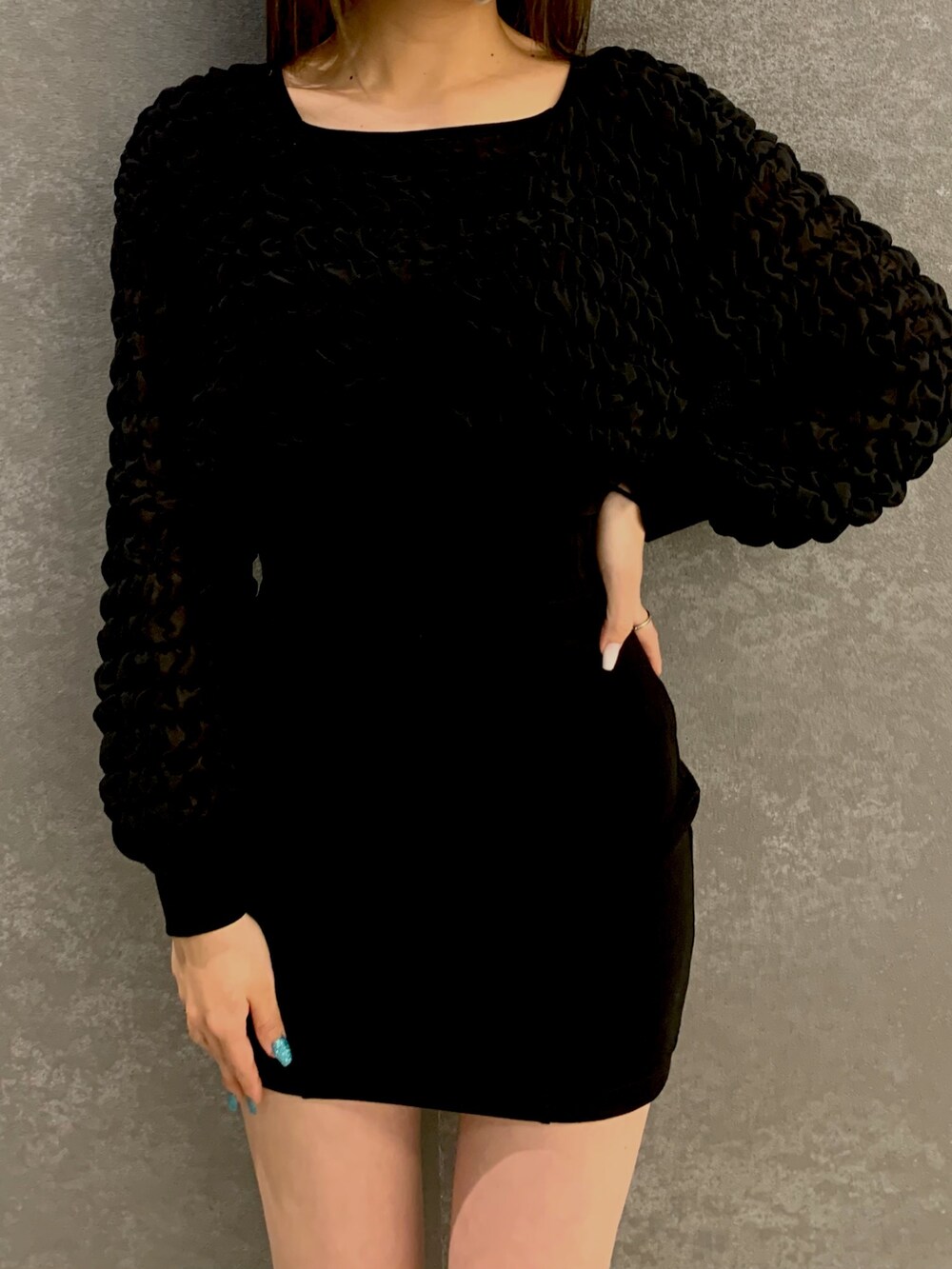 ブラック系のTシャツ/カットソー、ブラック系のスカート、ブラック系のブーツを着用したレディースの春コーディネートの2枚目の写真