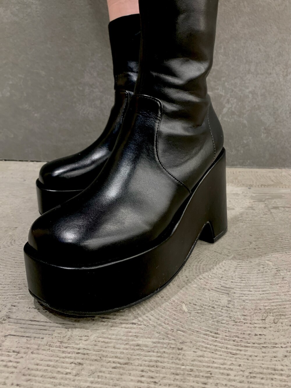 ブラック系のTシャツ/カットソー、ブラック系のスカート、ブラック系のブーツを着用したレディースの春コーディネートの3枚目の写真