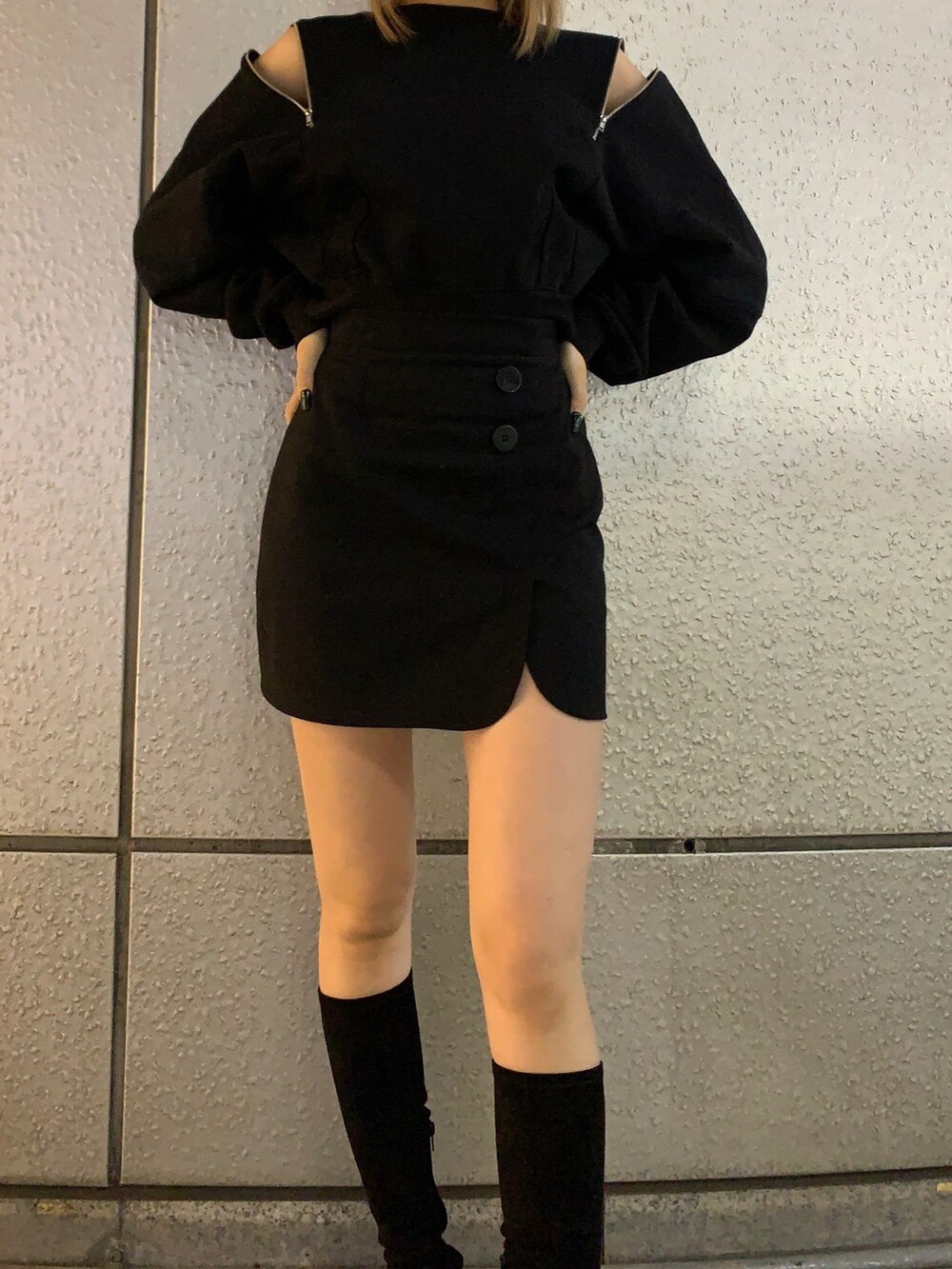 ブラック系のTシャツ/カットソー、ブラック系のスカート、ブラック系のブーツを着用したレディースの秋コーディネートの4枚目の写真