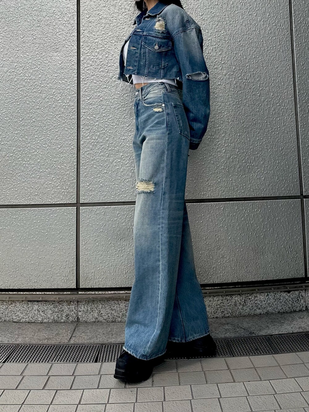 ブルー系のデニムジャケット、ブルー系のデニムパンツ、グレー系のスウェットを着用したレディースの冬コーディネートの3枚目の写真