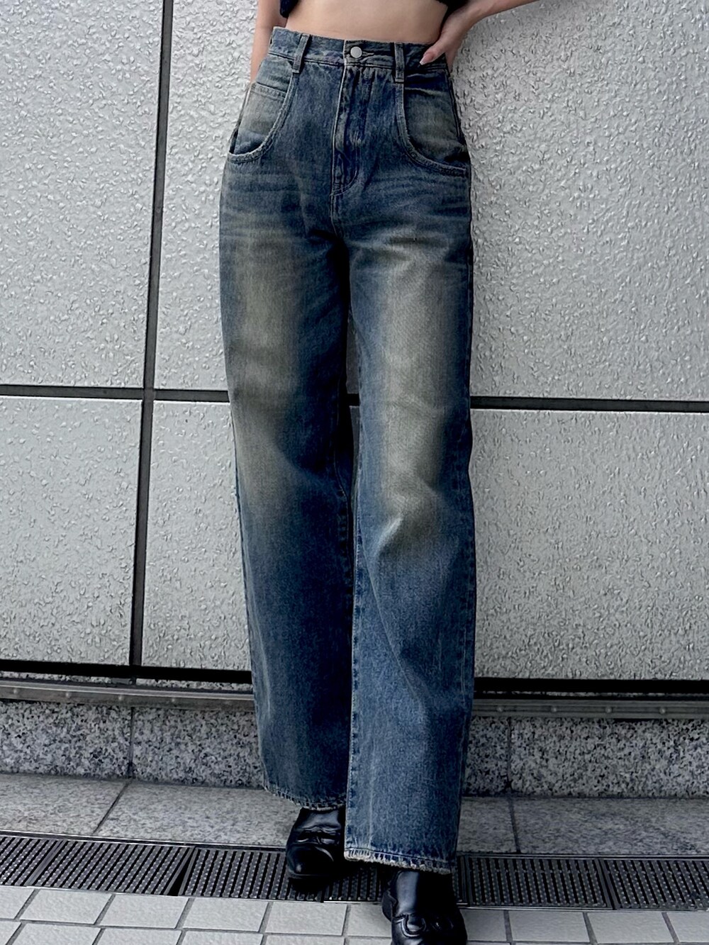 ブラック系のニット/セーター、ブルー系のデニムパンツ、ブラック系のキャップを着用したレディースの夏コーディネートの3枚目の写真