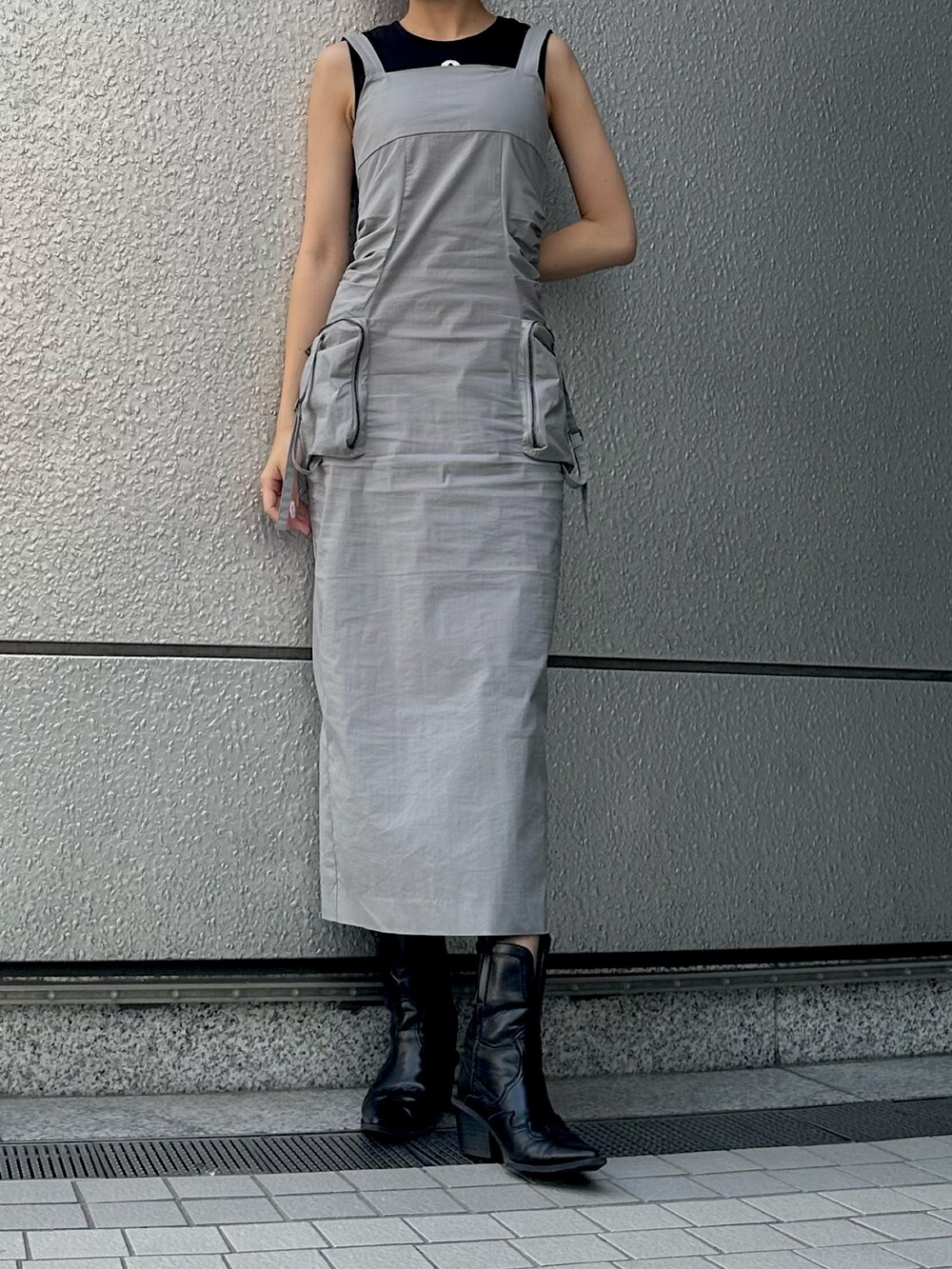 グレー系のワンピース、ブラック系のタンクトップ、ブラック系のブーツを着用したレディースの夏コーディネートの2枚目の写真