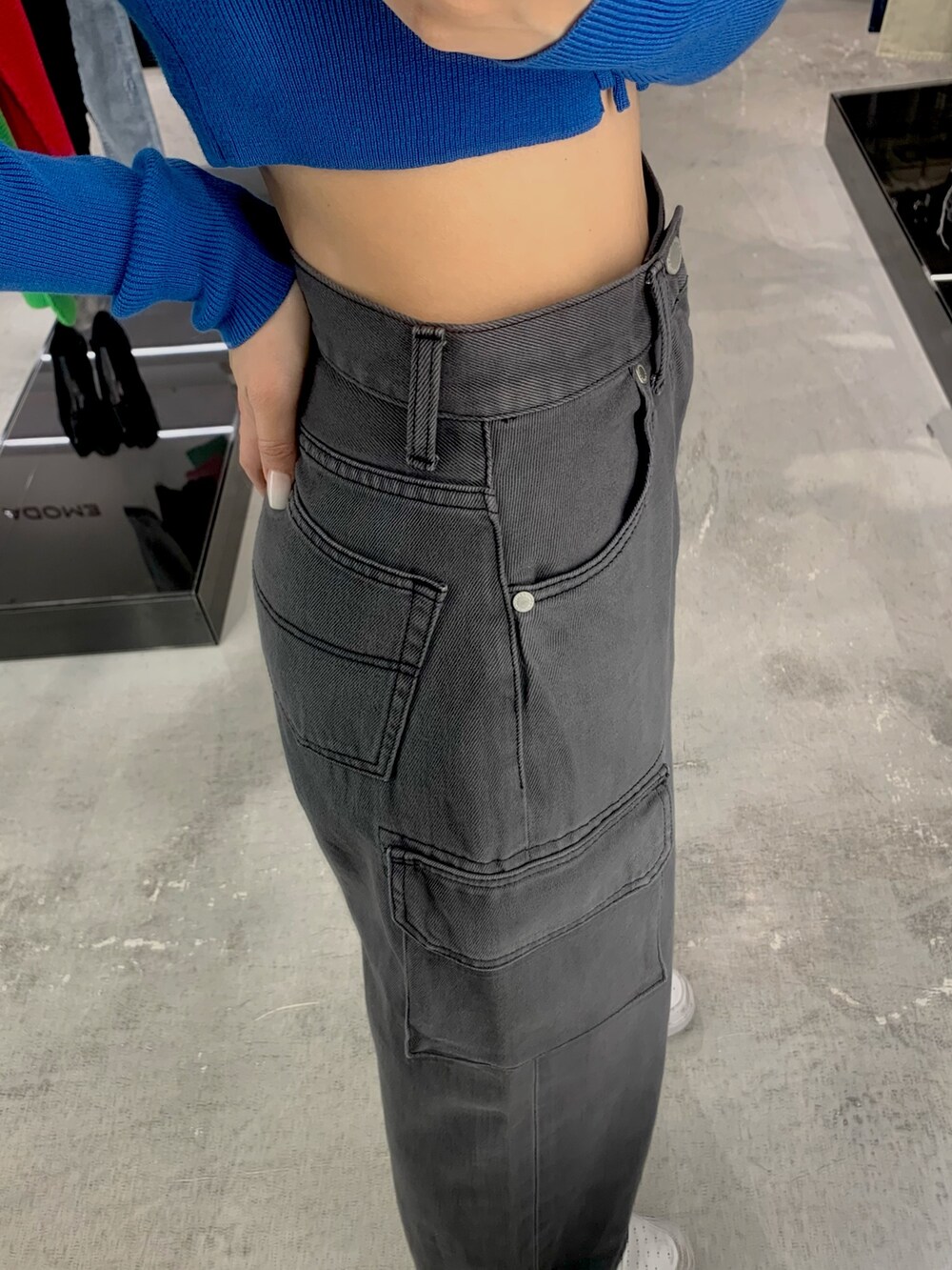 ブルー系のニット/セーター、ホワイト系のデニムパンツを着用したレディースの春コーディネートの2枚目の写真