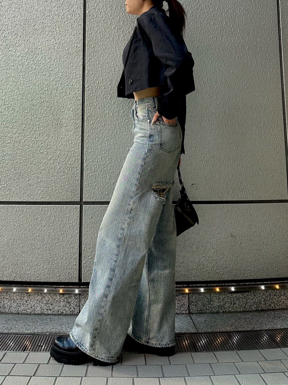 ホワイト系のTシャツ/カットソー、グレー系のテーラードジャケット、ブルー系のデニムパンツを着用したレディースの秋コーディネートの4枚目の写真