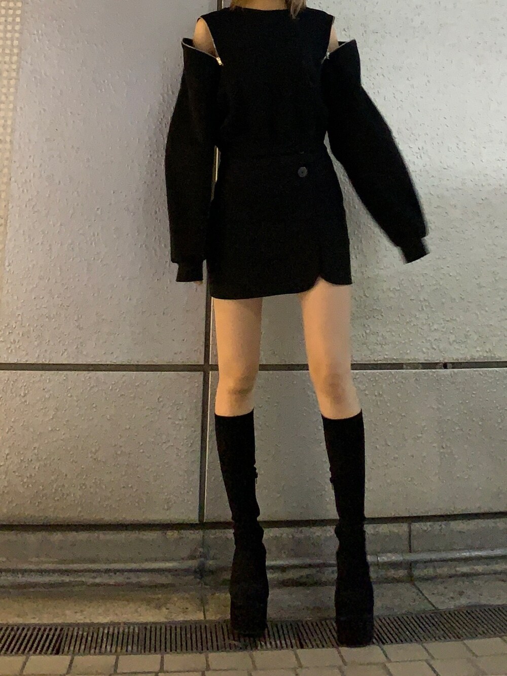 ブラック系のTシャツ/カットソー、ブラック系のスカート、ブラック系のブーツを着用したレディースの秋コーディネートの2枚目の写真