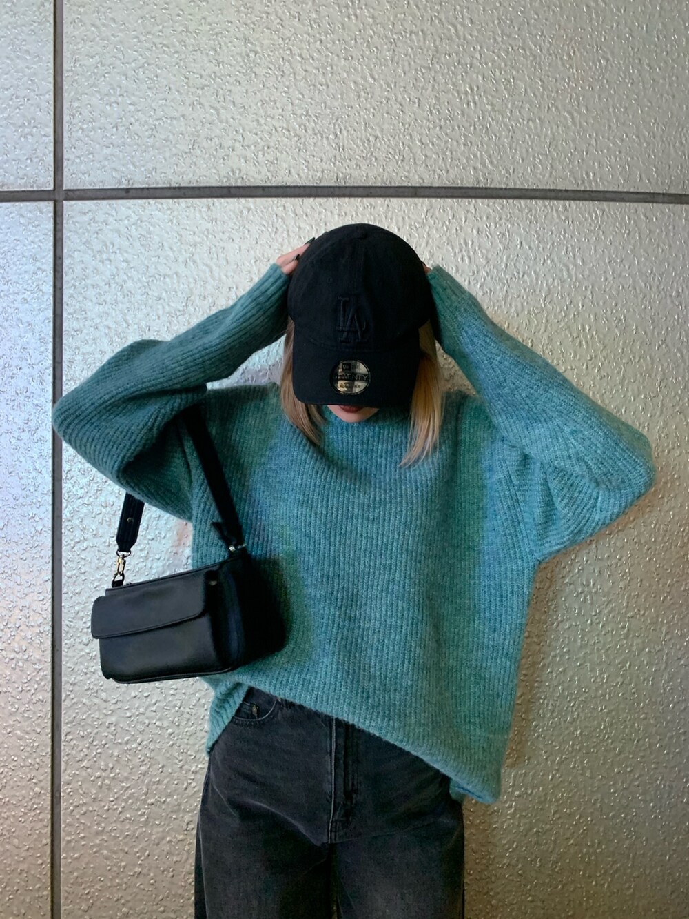 ブラック系のブーツ、グレー系のデニムパンツ、ブルー系のニット/セーターを着用したレディースの秋コーディネートの3枚目の写真