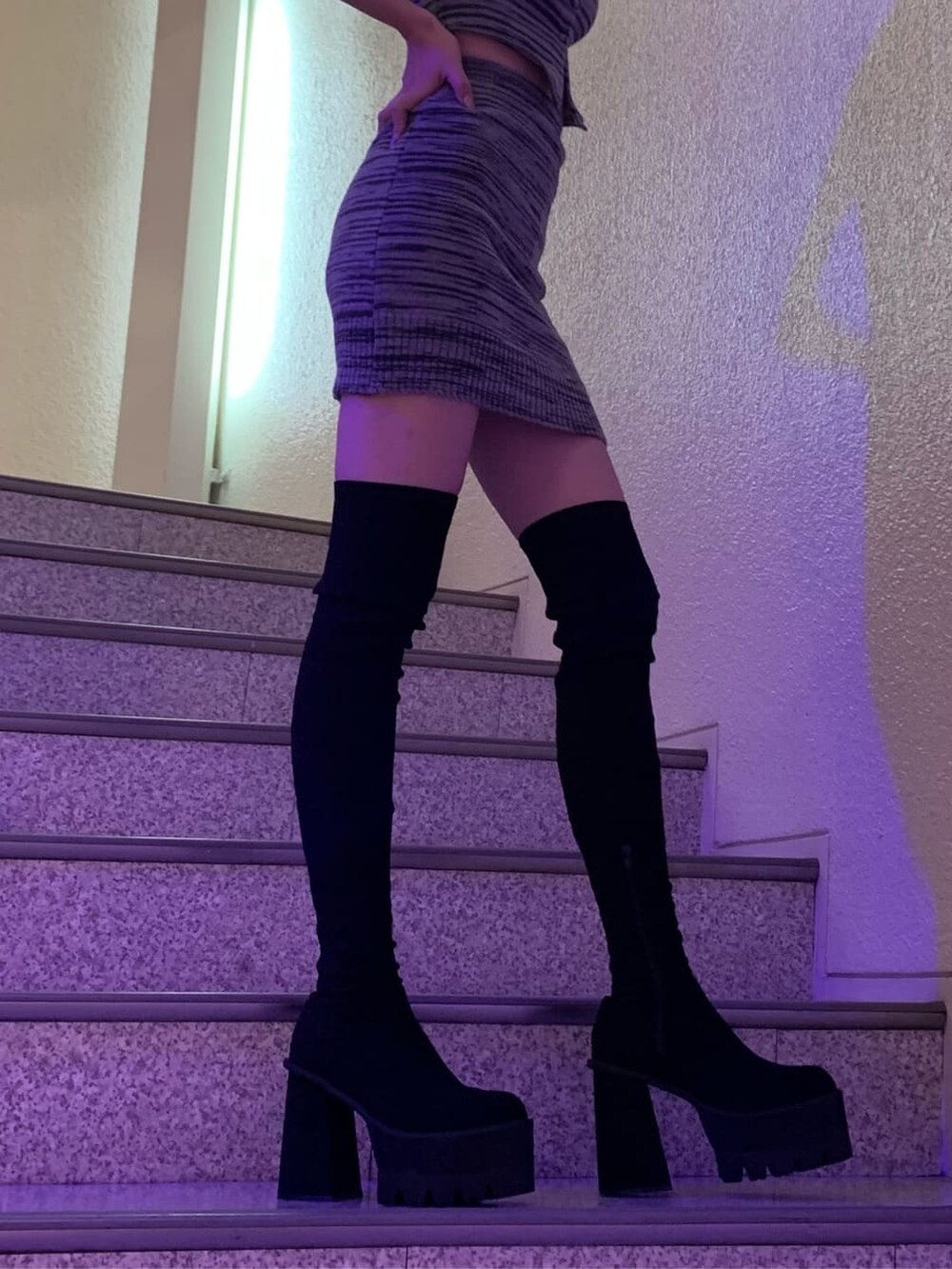 ブラック系のスカート、ブラック系のニット/セーター、ブラック系のブーツを着用したレディースの夏コーディネートの3枚目の写真