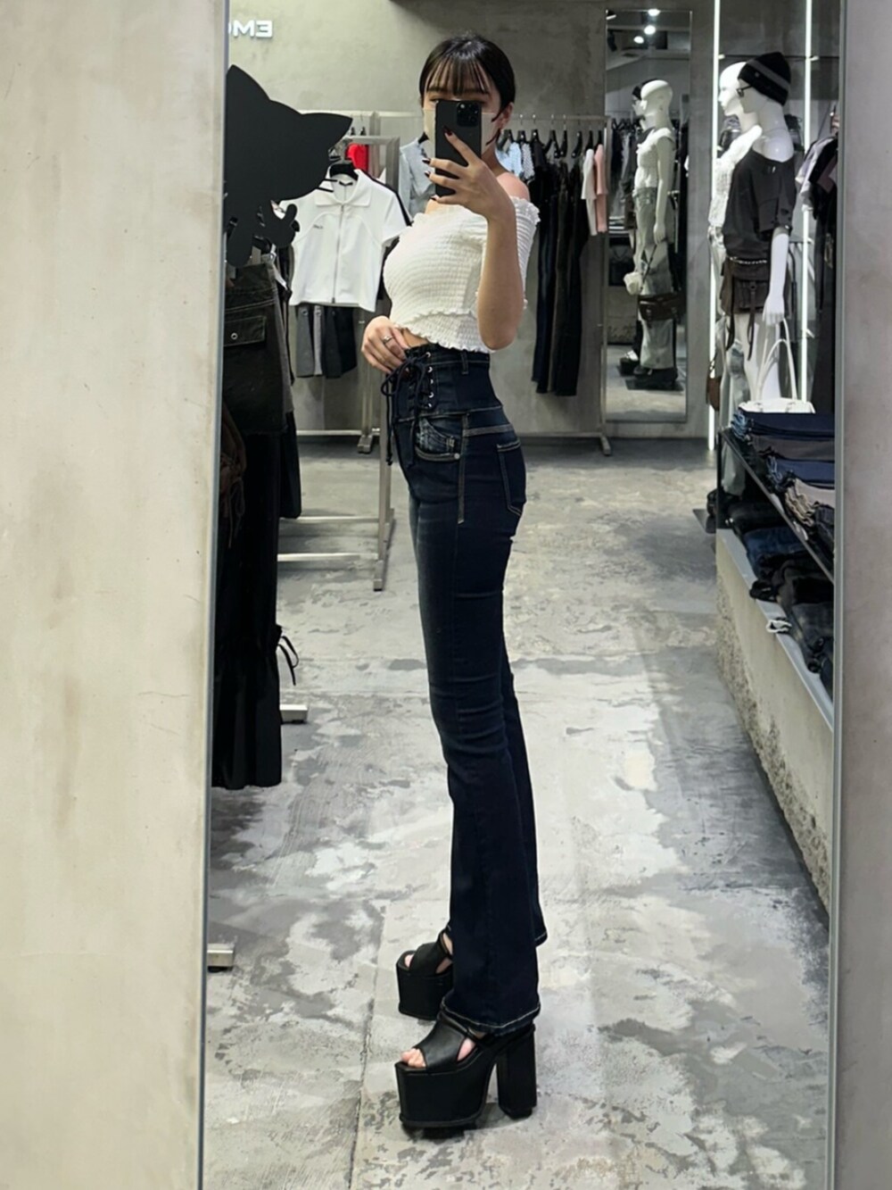 ブラック系のサンダル、ホワイト系のTシャツ/カットソー、ブルー系のデニムパンツを着用したレディースの夏コーディネートの2枚目の写真