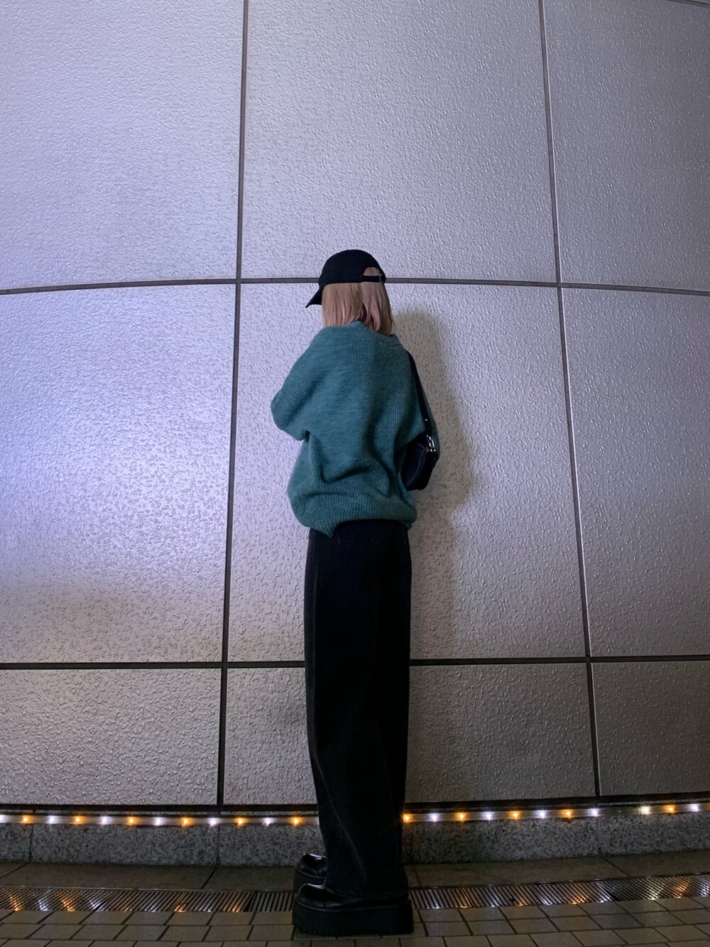 ブラック系のブーツ、グレー系のデニムパンツ、ブルー系のニット/セーターを着用したレディースの秋コーディネートの2枚目の写真