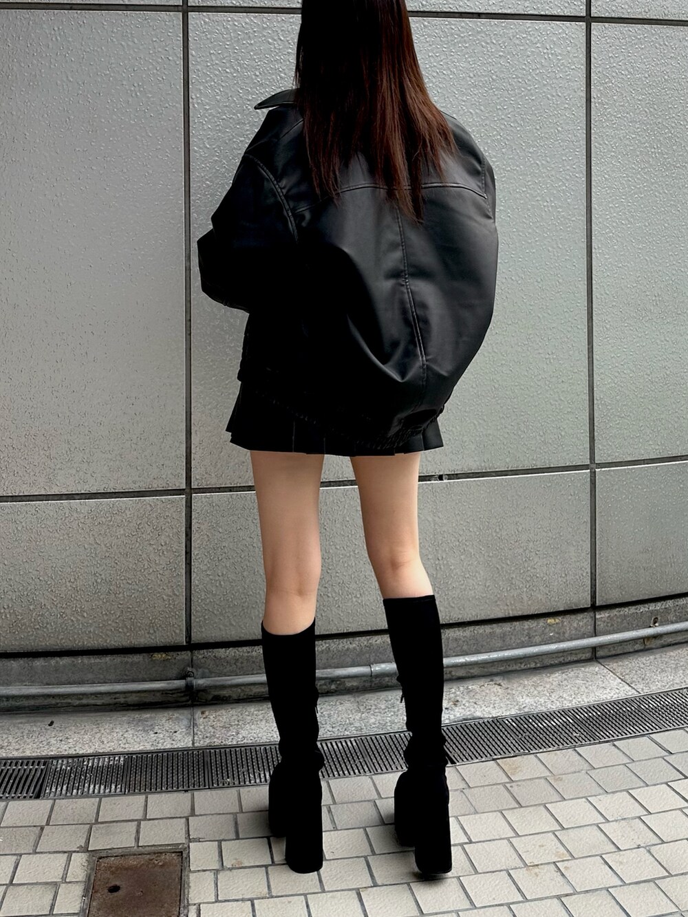 ブラック系のブルゾン、ブラック系のニット/セーター、ブラック系のスカートを着用したレディースの秋コーディネートの4枚目の写真