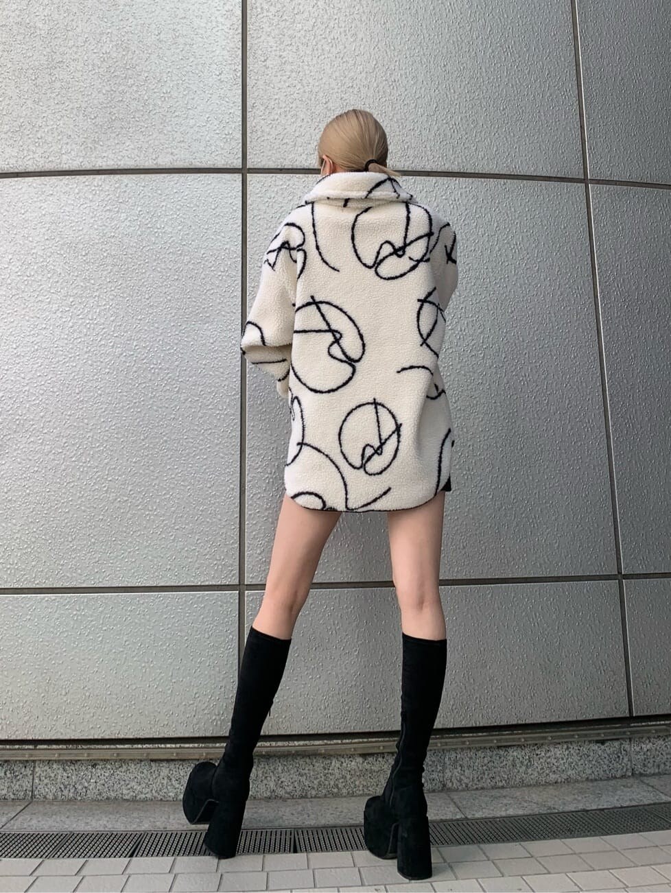 ブラック系のブーツ、ブラック系のスカート、その他のTシャツ/カットソーを着用したレディースの秋コーディネートの2枚目の写真