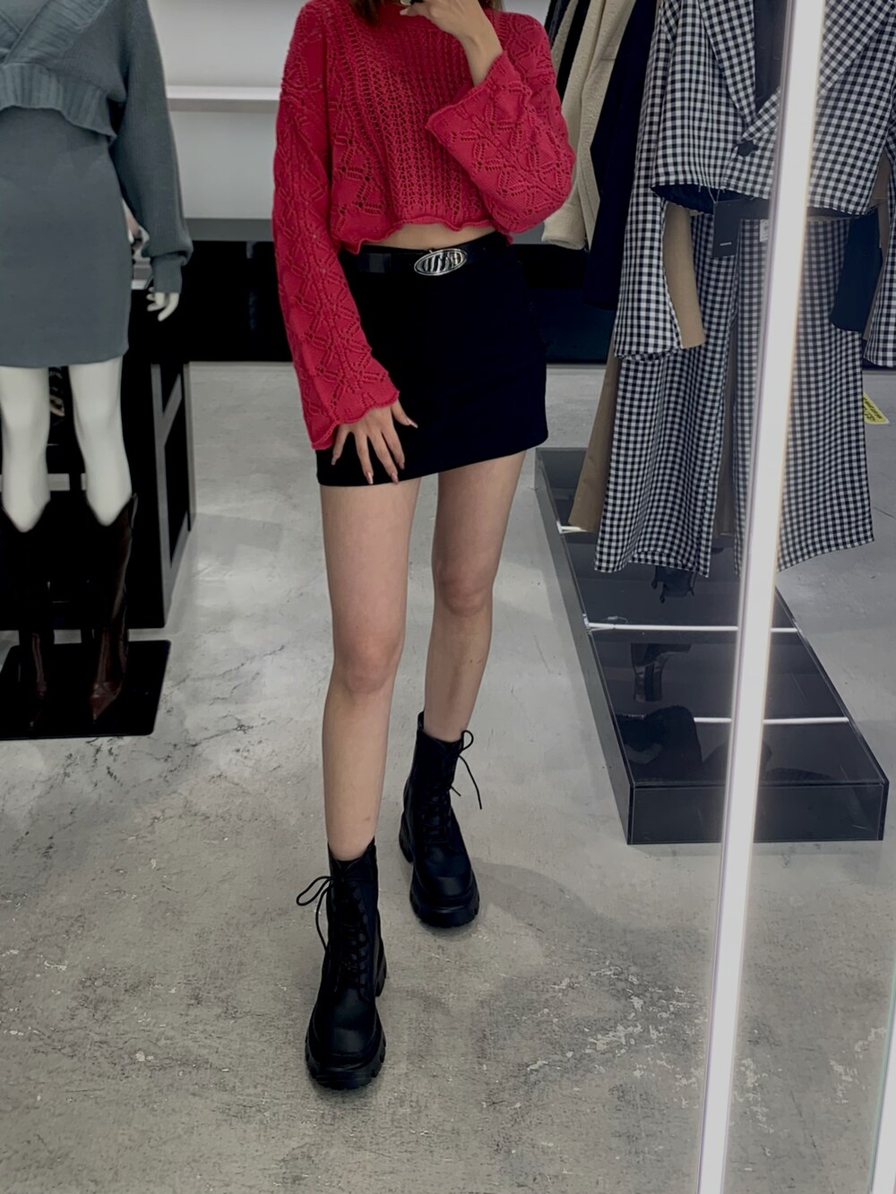 ピンク系のニット/セーター、ブラック系のスカート、ブラック系のブーツを着用したレディースの冬コーディネートの2枚目の写真