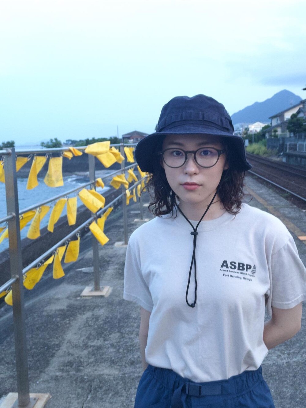 ベージュ系のTシャツ/カットソー、ブルー系のその他パンツ、ブルー系の帽子を着用したレディースの夏コーディネートの2枚目の写真