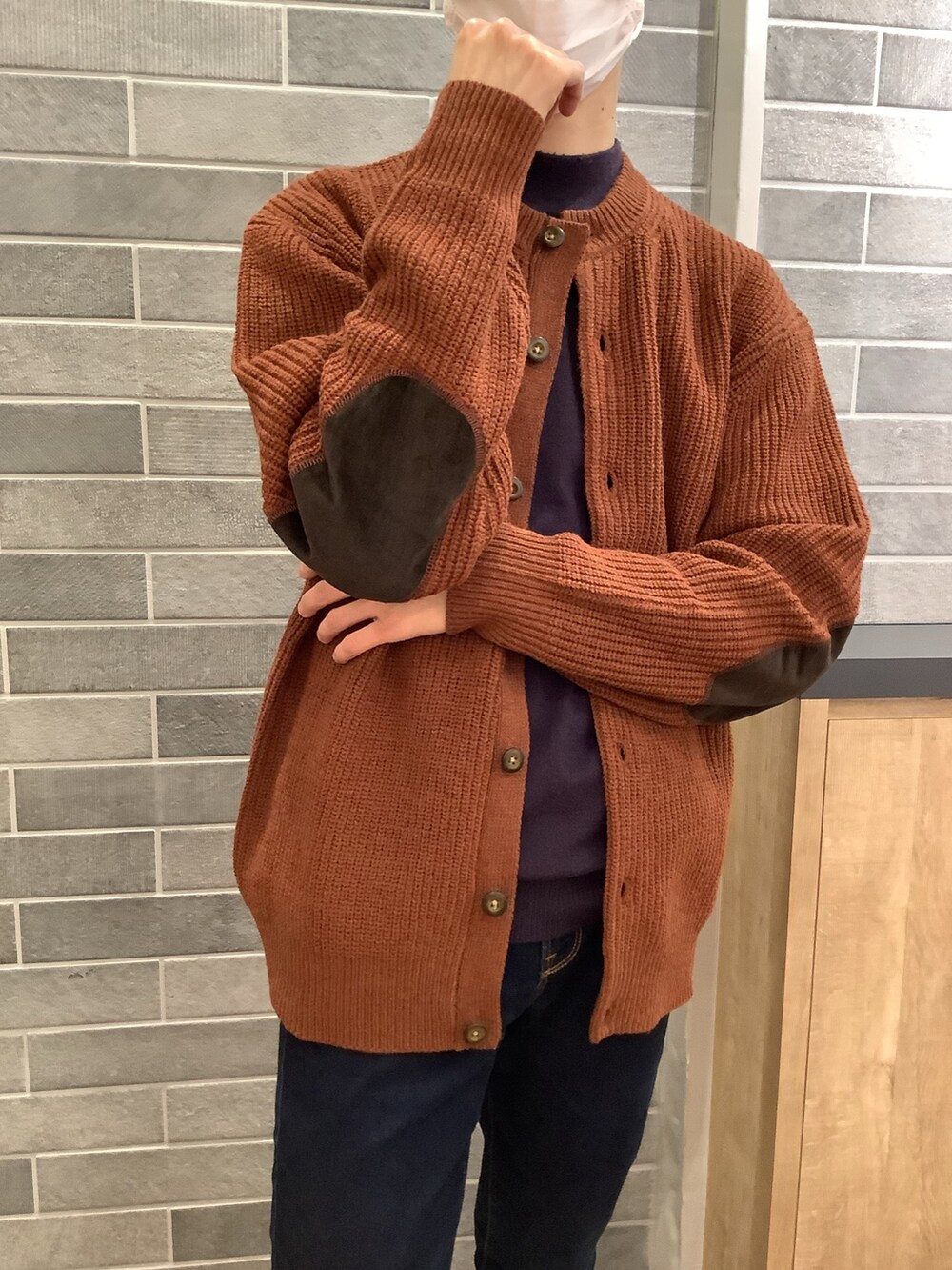 オレンジ系のカーディガン/ボレロを着用したメンズの冬コーディネートの2枚目の写真