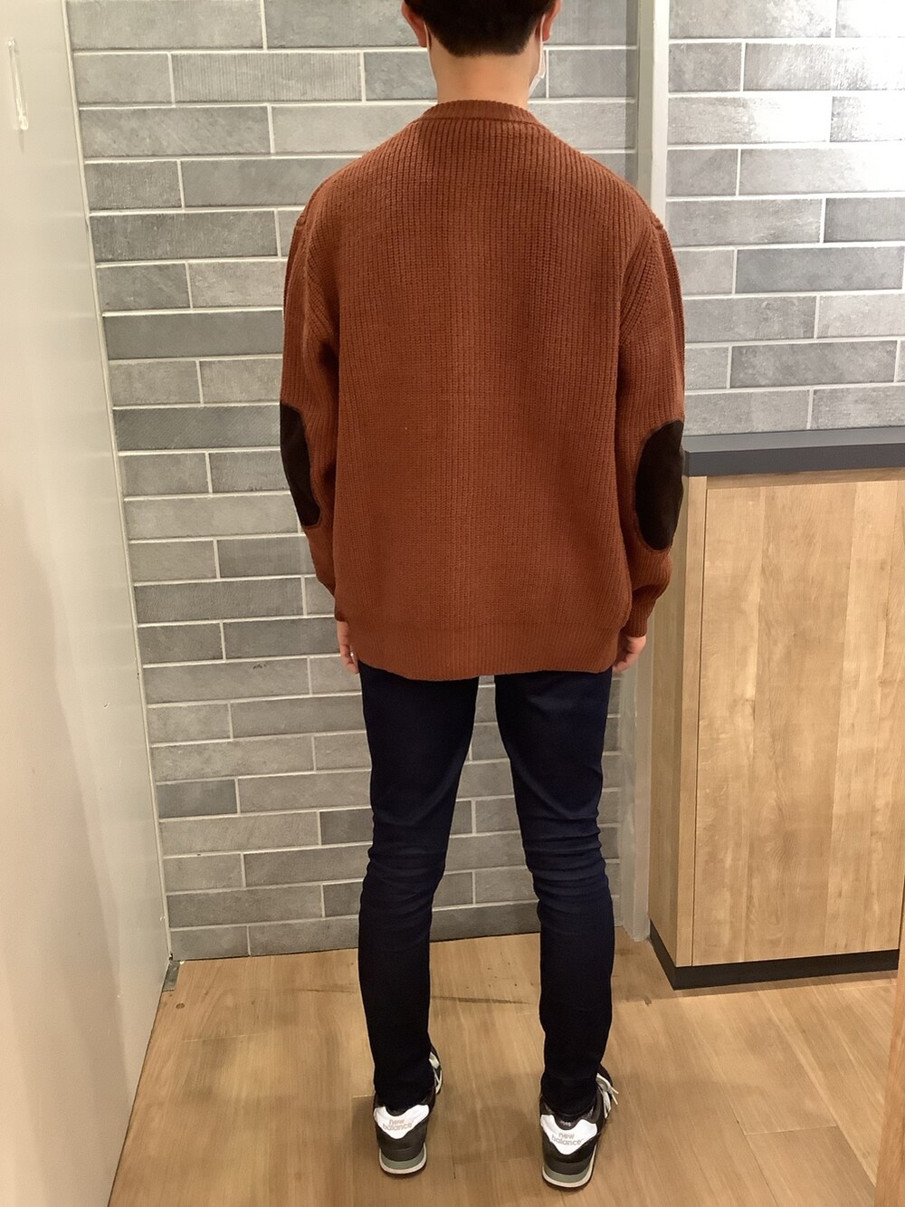 オレンジ系のカーディガン/ボレロを着用したメンズの冬コーディネートの3枚目の写真