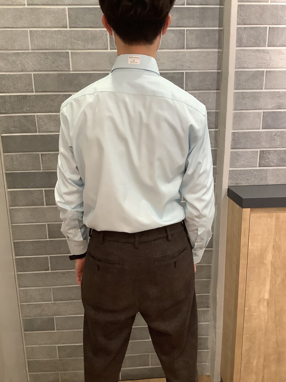 グリーン系のビジネスシャツを着用したメンズの冬コーディネートの2枚目の写真