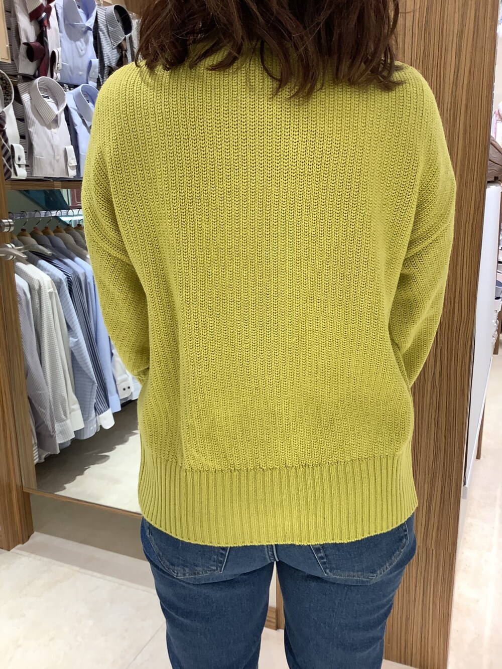 イエロー系のニット/セーターを着用したレディースの冬コーディネートの2枚目の写真