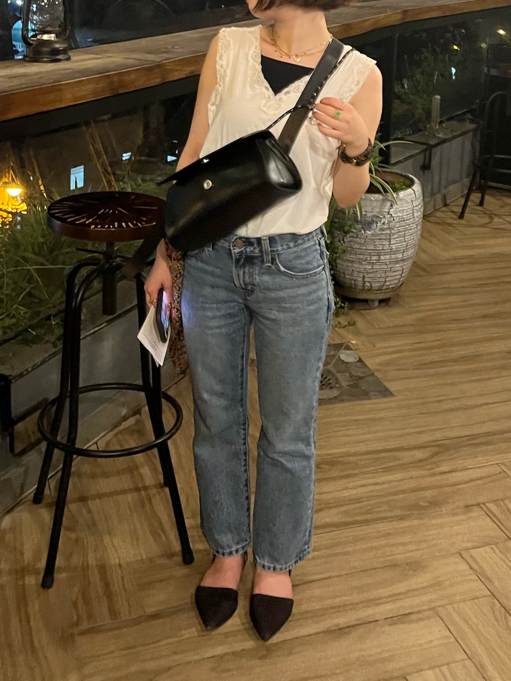 ブルー系のデニムパンツ、ブラック系のショルダーバッグを着用したレディースの冬コーディネートの2枚目の写真