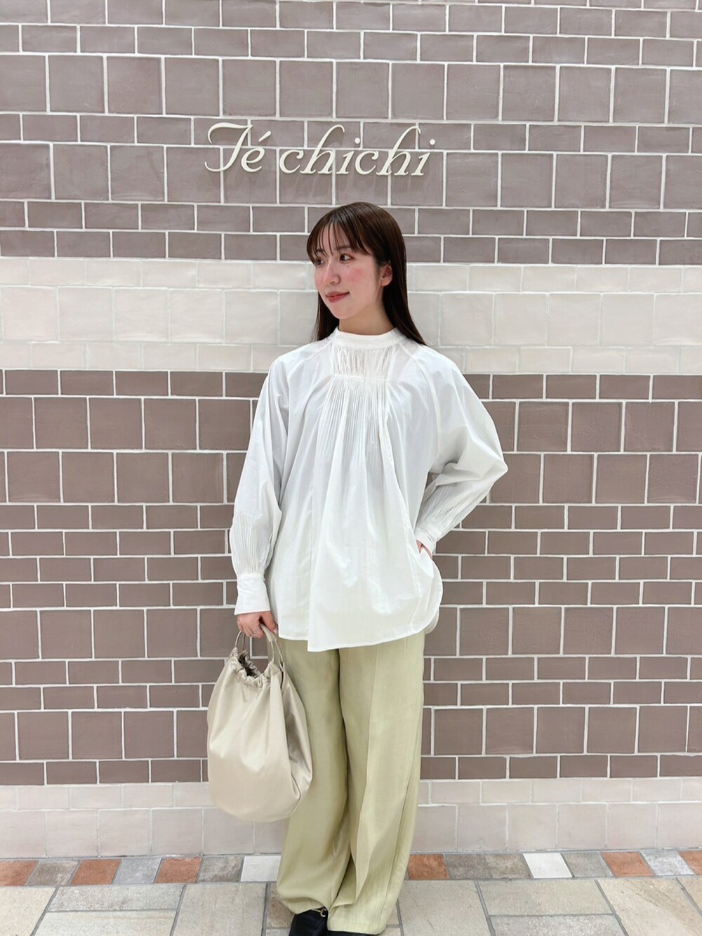 ホワイト系のシャツ/ブラウス、ベージュ系のトートバッグ、グリーン系のパンツを着用したレディースの春コーディネートの3枚目の写真