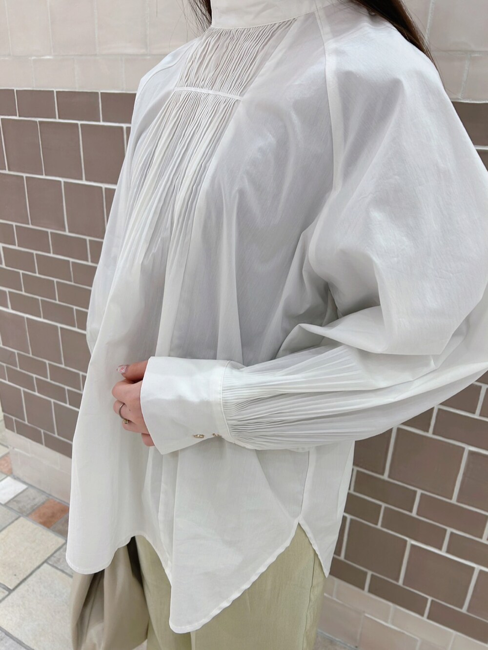 ホワイト系のシャツ/ブラウス、ベージュ系のトートバッグ、グリーン系のパンツを着用したレディースの春コーディネートの4枚目の写真