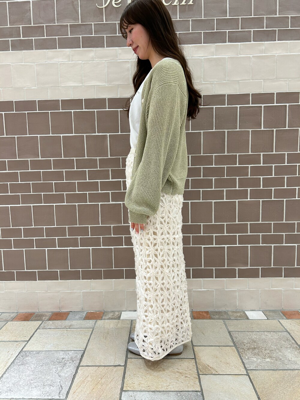 ゴールド系のTシャツ/カットソー、ホワイト系のスカート、ゴールド系のカーディガン/ボレロを着用したレディースの春コーディネートの2枚目の写真