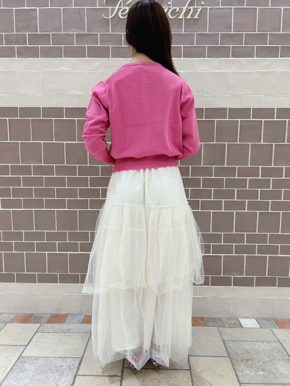 ピンク系のカーディガン/ボレロ、ホワイト系のスカート、ホワイト系のパンプスを着用したレディースの春コーディネートの3枚目の写真