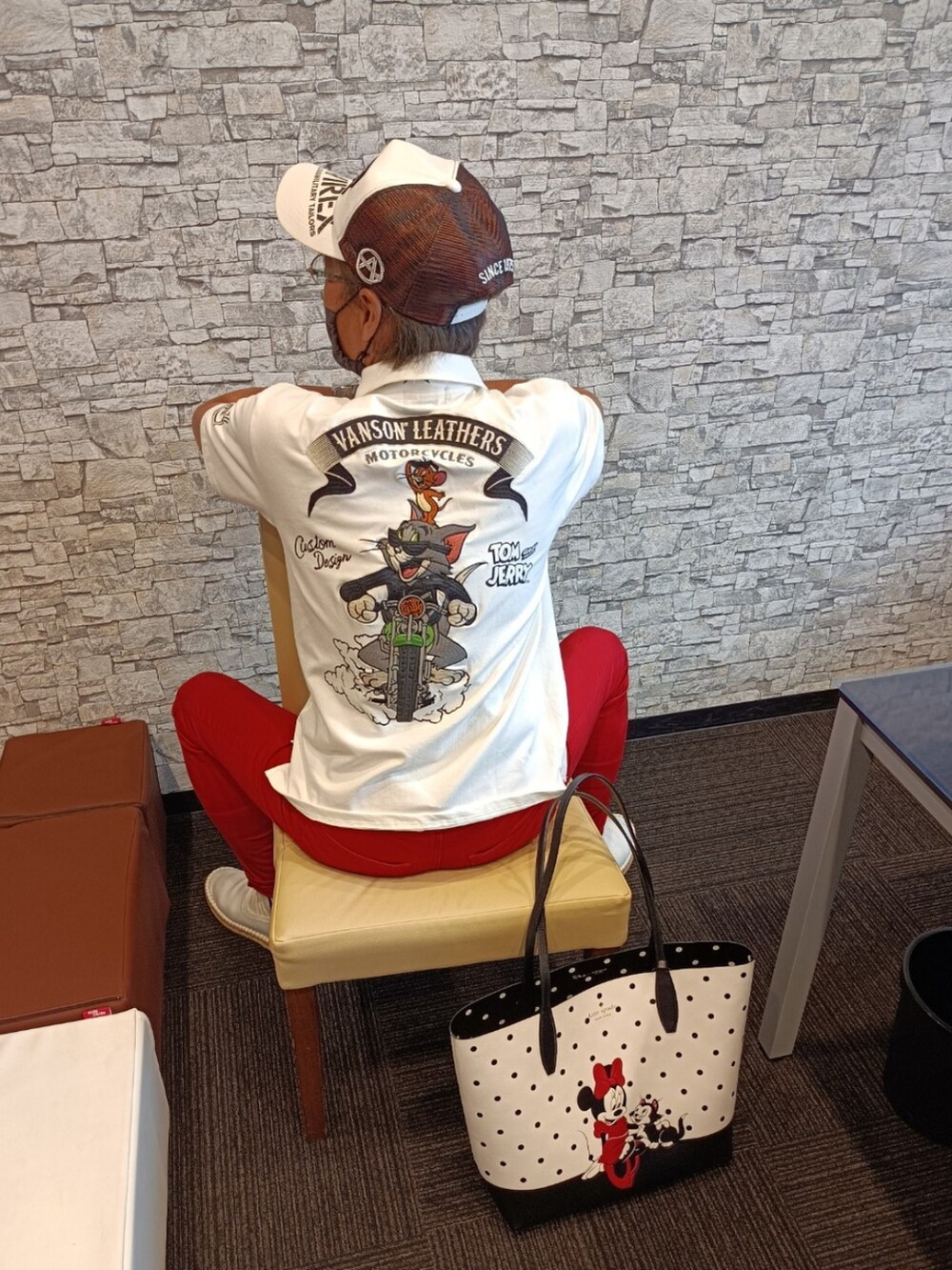 ホワイト系のショルダーバッグ、ホワイト系のポロシャツ、レッド系のデニムパンツを着用したメンズの夏コーディネートの2枚目の写真