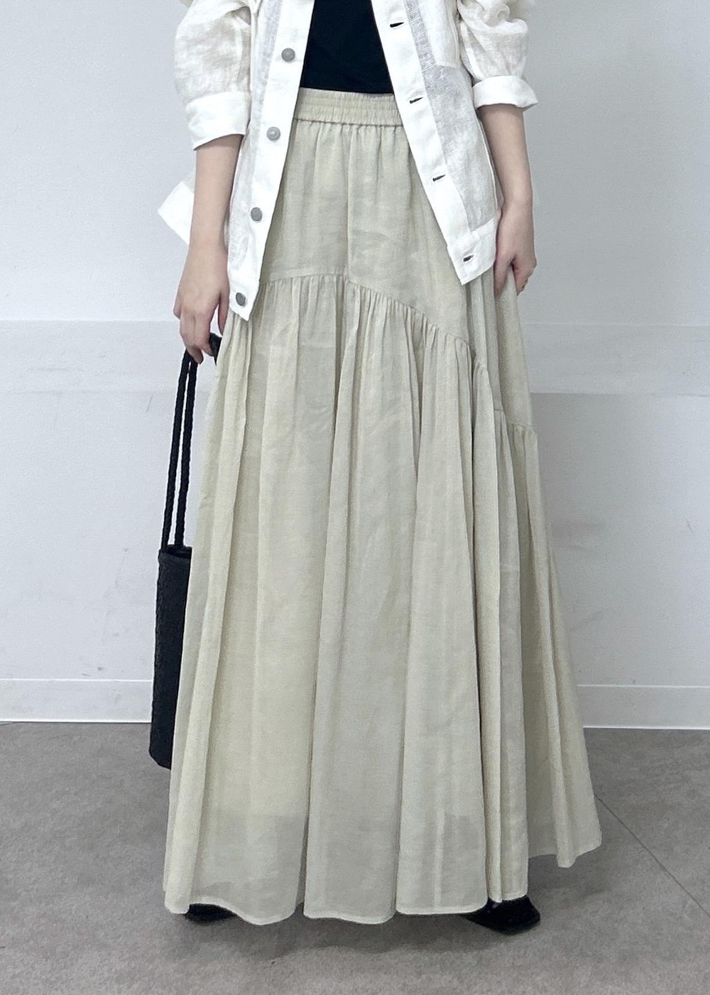ブラック系のキャミソール、ブラック系のその他シューズ、ベージュ系のスカートを着用したレディースの春コーディネートの5枚目の写真