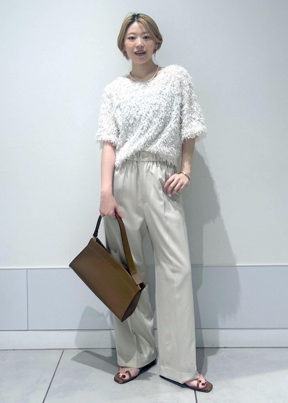 ブラウン系のショルダーバッグ、ホワイト系のTシャツ/カットソー、ベージュ系のその他パンツを着用したレディースの夏コーディネートの4枚目の写真
