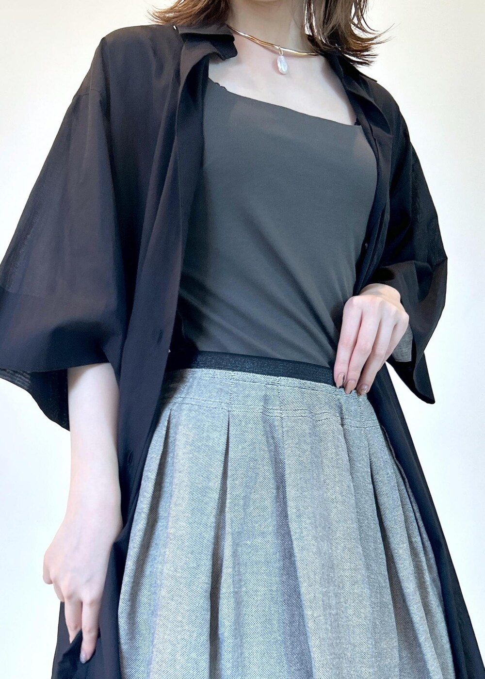 ブラック系のサンダル、ブラック系のシャツワンピース、グリーン系のタンクトップを着用したレディースの夏コーディネートの5枚目の写真