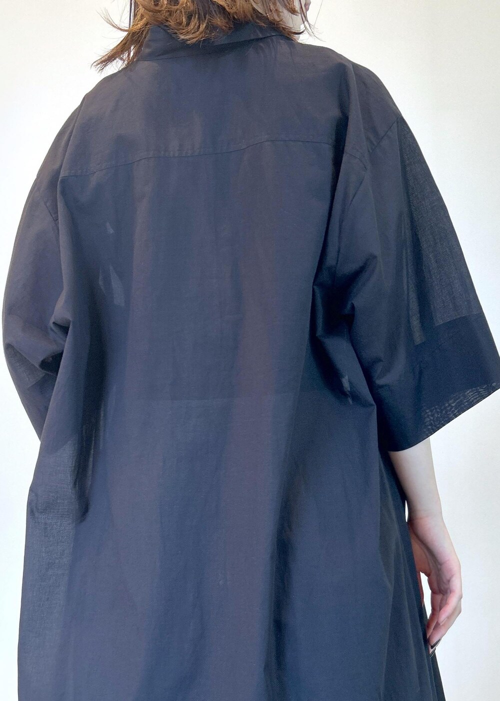 ブラック系のサンダル、ブラック系のシャツワンピース、グリーン系のタンクトップを着用したレディースの夏コーディネートの6枚目の写真