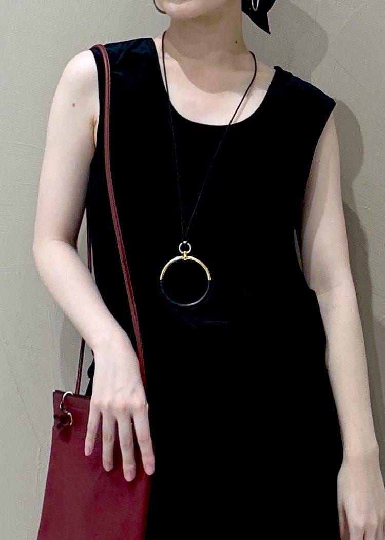 ブラック系のタンクトップ、ブラック系のスカート、ブラック系のパンプスを着用したレディースの夏コーディネートの4枚目の写真