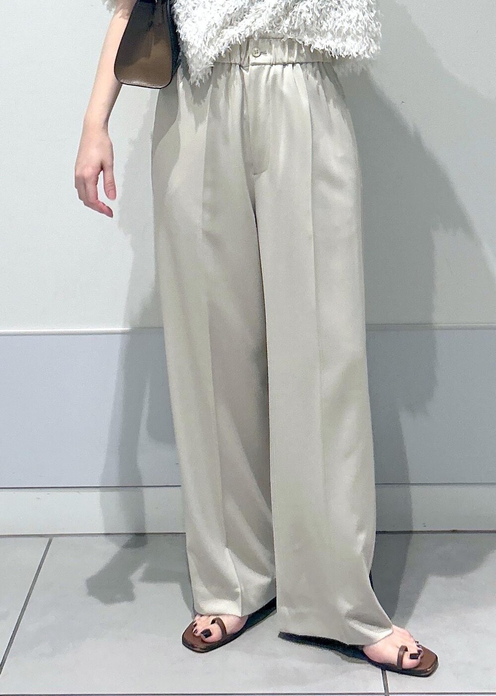 ブラウン系のショルダーバッグ、ホワイト系のTシャツ/カットソー、ベージュ系のその他パンツを着用したレディースの夏コーディネートの6枚目の写真