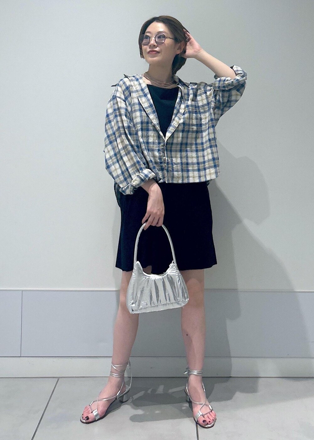 シルバー系のサンダル、ブラック系のラッシュガードを着用したレディースの夏コーディネートの3枚目の写真