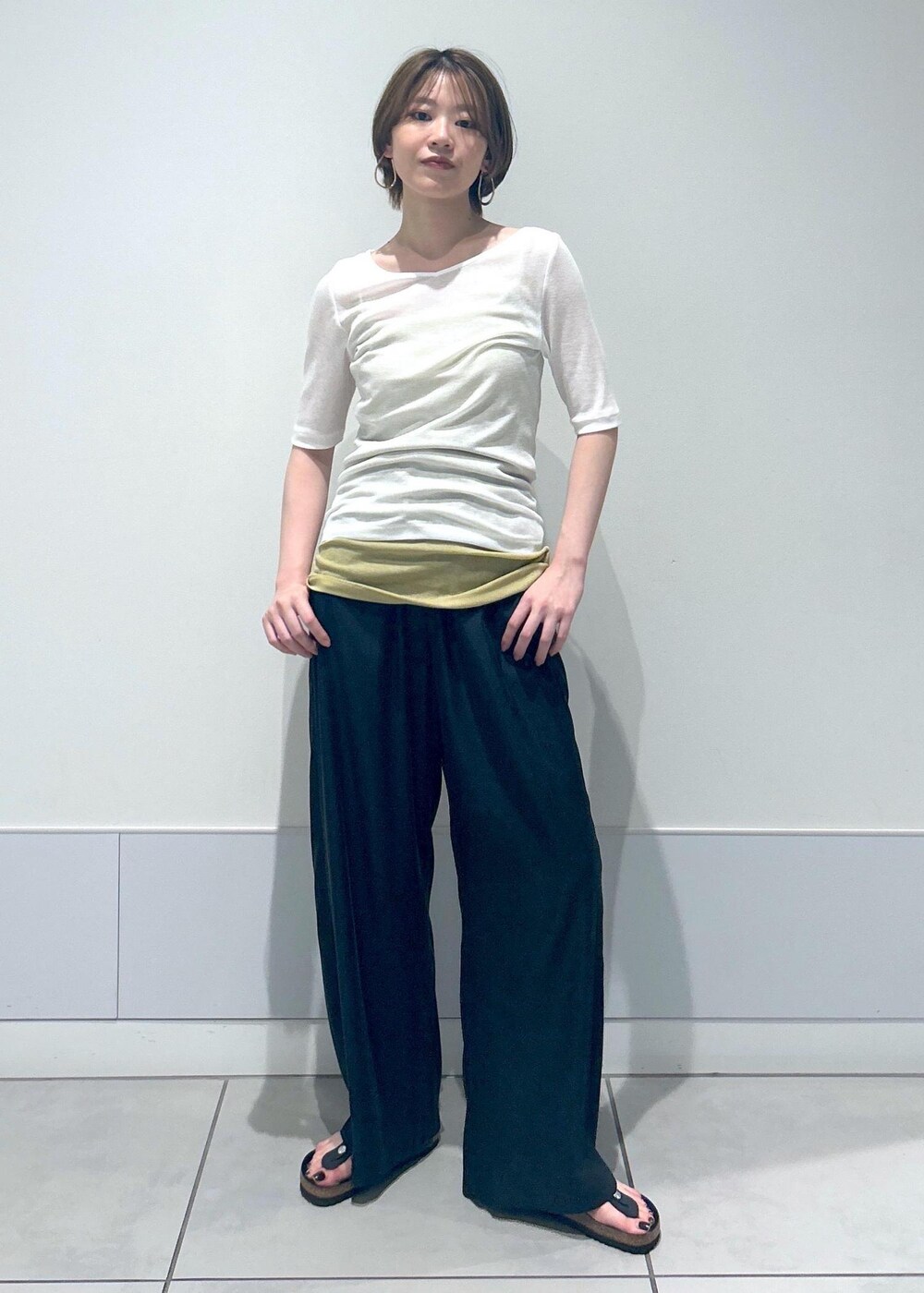 イエロー系のキャミソール、ホワイト系のTシャツ/カットソー、ブラック系のその他パンツを着用したレディースの春コーディネートの2枚目の写真