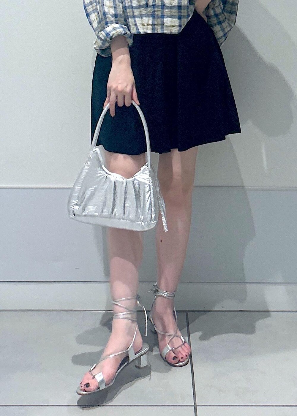 シルバー系のサンダル、ブラック系のラッシュガードを着用したレディースの夏コーディネートの6枚目の写真