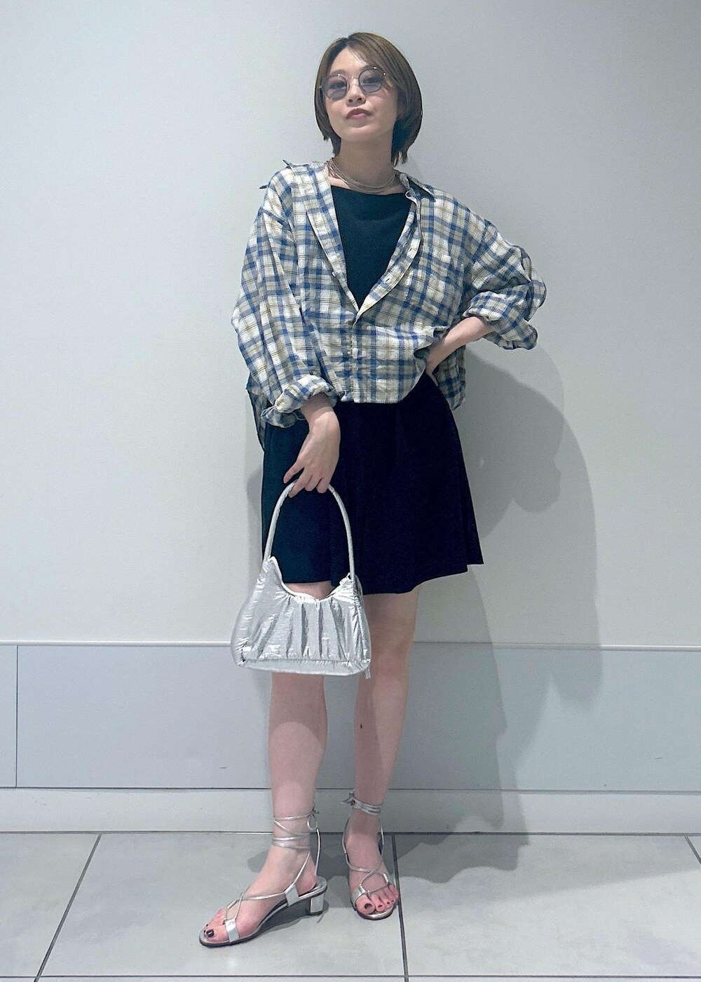 シルバー系のサンダル、ブラック系のラッシュガードを着用したレディースの夏コーディネートの4枚目の写真