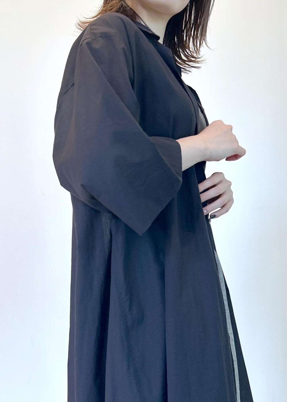 ブラック系のサンダル、ブラック系のシャツワンピース、グリーン系のタンクトップを着用したレディースの夏コーディネートの7枚目の写真