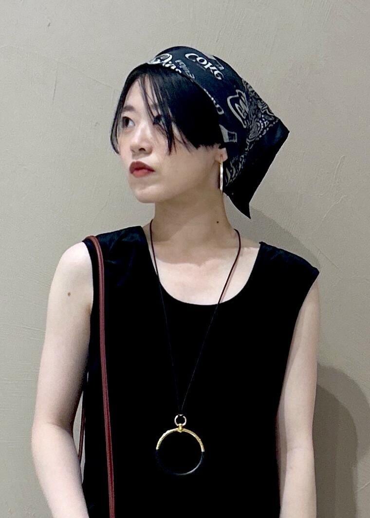 ブラック系のタンクトップ、ブラック系のスカート、ブラック系のパンプスを着用したレディースの夏コーディネートの6枚目の写真