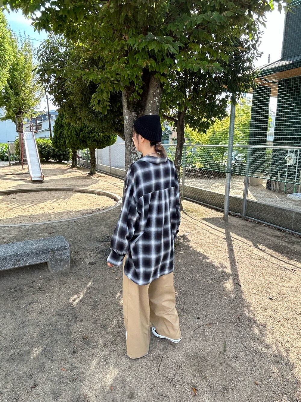 ブラック系のスニーカー、ブラック系のシャツ/ブラウス、ブラック系のスラックスを着用したレディースの秋コーディネートの4枚目の写真