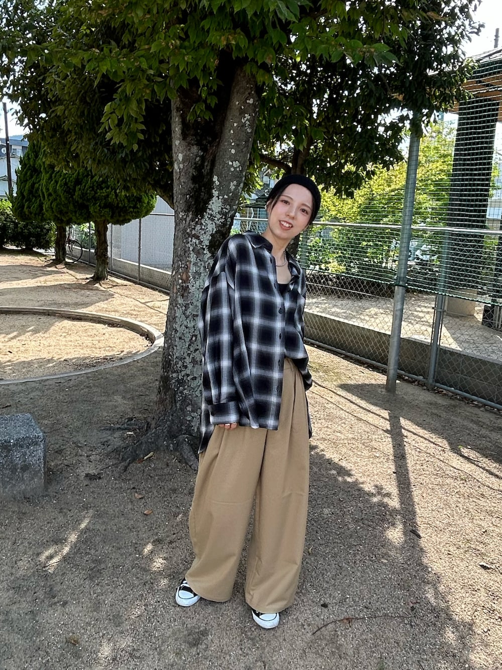 ブラック系のスニーカー、ブラック系のシャツ/ブラウス、ブラック系のスラックスを着用したレディースの秋コーディネートの2枚目の写真