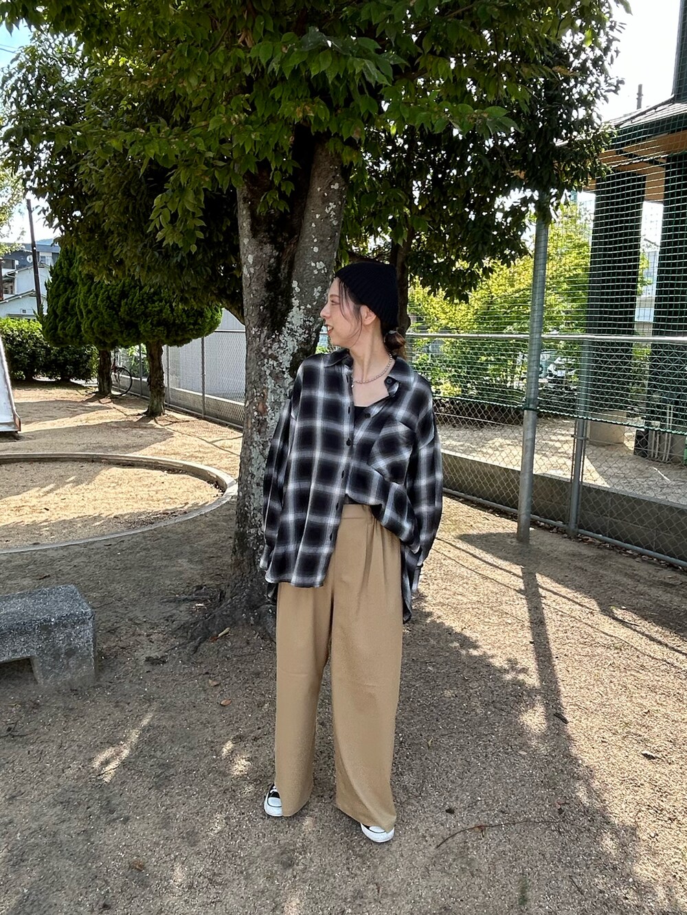 ブラック系のスニーカー、ブラック系のシャツ/ブラウス、ブラック系のスラックスを着用したレディースの秋コーディネートの3枚目の写真