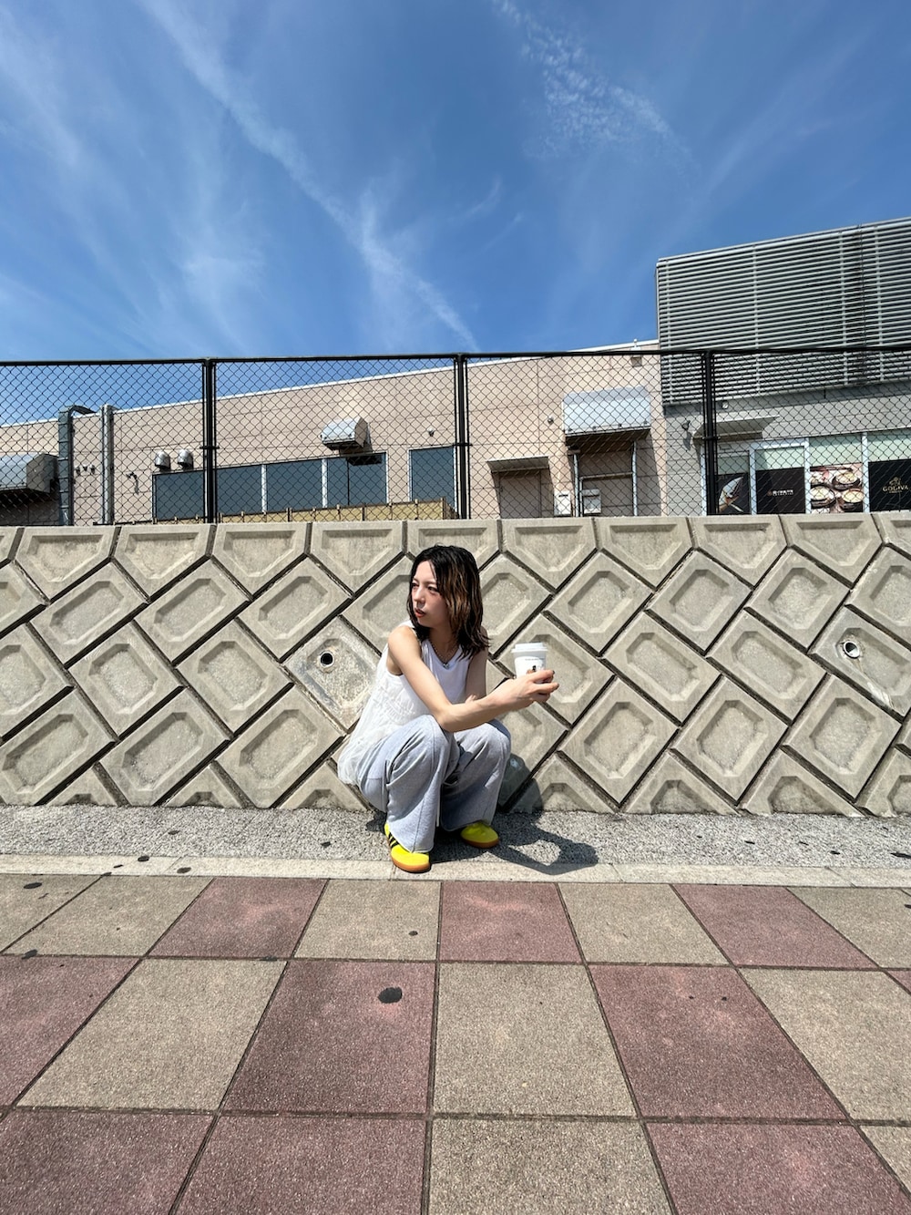 ホワイト系のキャミソール、グレー系のスウェットパンツ、イエロー系のスニーカーを着用したレディースの夏コーディネートの3枚目の写真