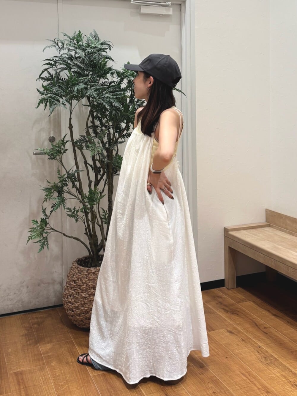 イエロー系のタンクトップ、ホワイト系のワンピース、ブルー系のデニムパンツを着用したレディースの夏コーディネートの3枚目の写真