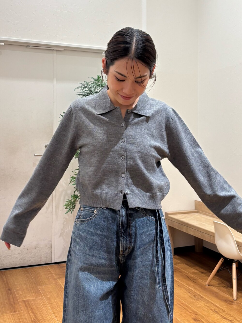 レッド系のカーディガン/ボレロ、ブルー系のデニムパンツ、ゴールド系のバレエシューズを着用したレディースの秋コーディネートの6枚目の写真