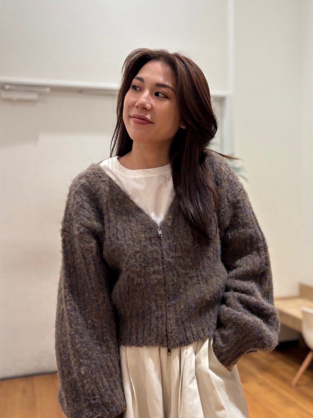 ブラウン系のカーディガン/ボレロ、ホワイト系のその他パンツ、ブラック系のスリッポンを着用したレディースの冬コーディネートの5枚目の写真