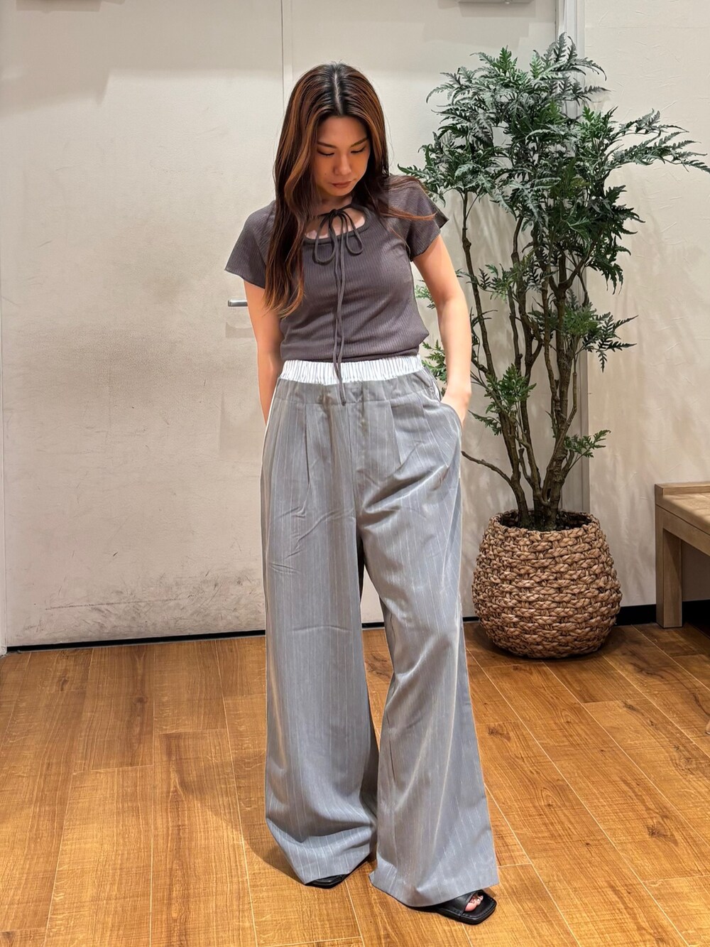 グレー系のTシャツ/カットソー、グレー系のその他パンツ、ブラック系のサンダルを着用したレディースの春コーディネートの2枚目の写真