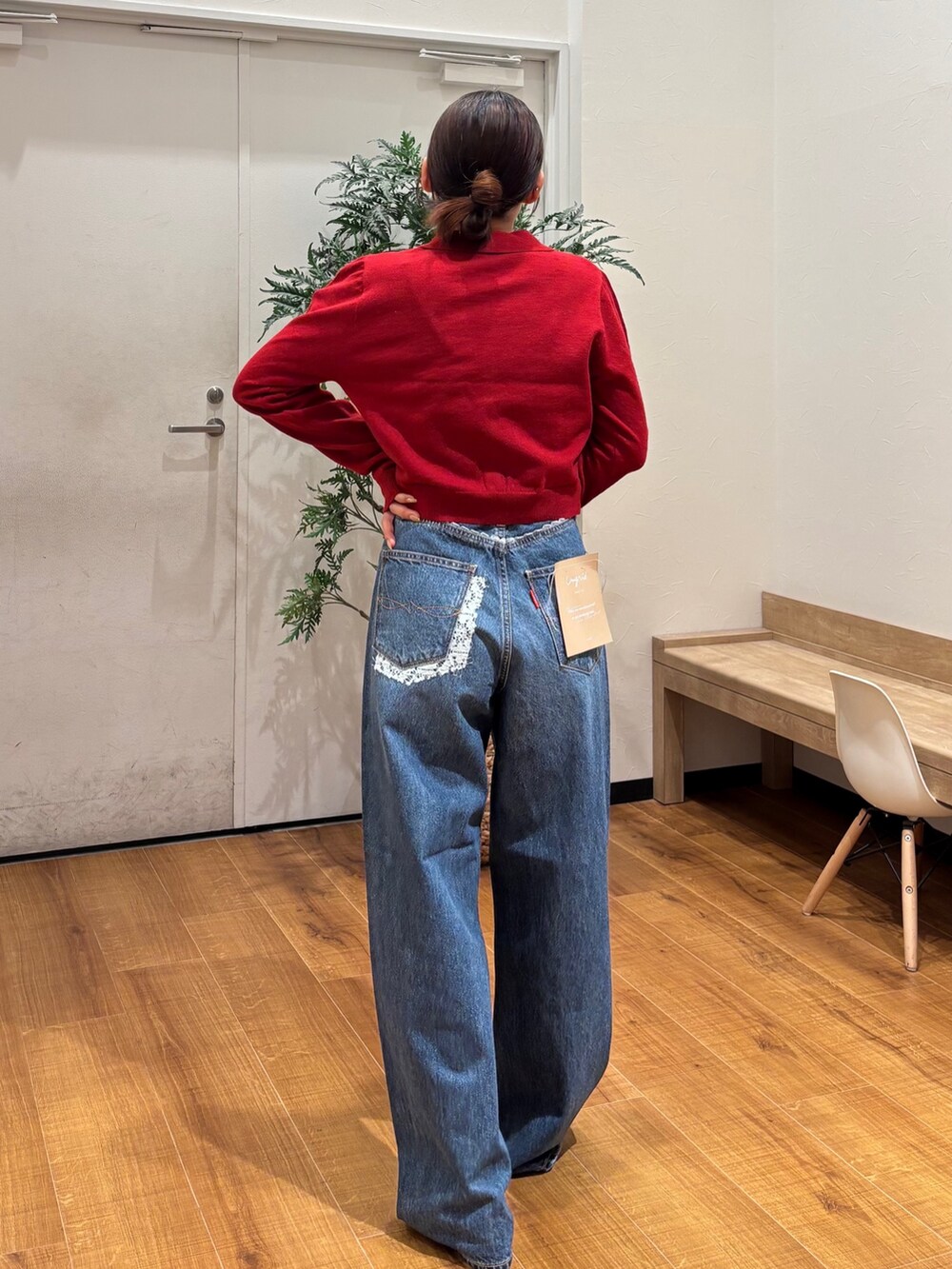 レッド系のカーディガン/ボレロ、ブルー系のデニムパンツ、ゴールド系のバレエシューズを着用したレディースの秋コーディネートの4枚目の写真